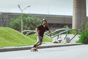 Image showing Skateboarder doing a trick at the city\'s street in sunny day