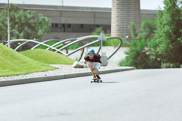 Image showing Skateboarder doing a trick at the city\'s street in sunny day