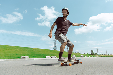 Image showing Skateboarder doing a trick at the city\'s street in sunny day