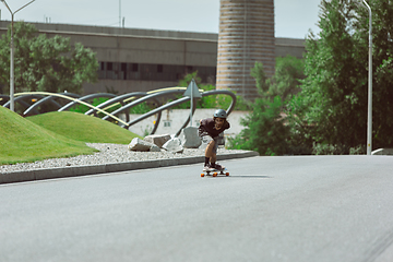 Image showing Skateboarder doing a trick at the city\'s street in sunny day