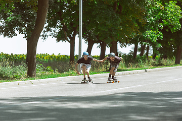 Image showing Skateboarders doing a trick at the city\'s street in sunny day