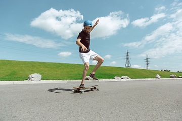 Image showing Skateboarder doing a trick at the city\'s street in sunny day