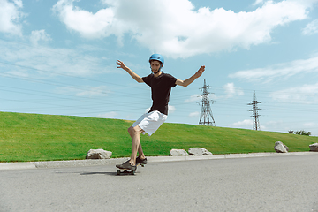 Image showing Skateboarder doing a trick at the city\'s street in sunny day