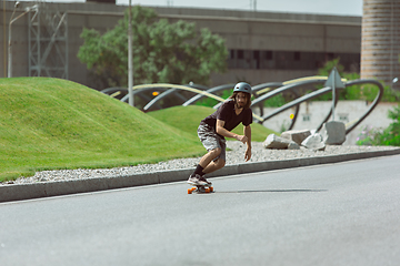 Image showing Skateboarder doing a trick at the city\'s street in sunny day