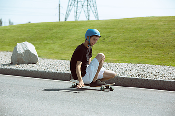 Image showing Skateboarder doing a trick at the city\'s street in sunny day