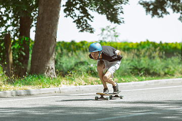 Image showing Skateboarder doing a trick at the city\'s street in sunny day