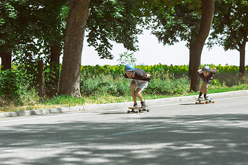 Image showing Skateboarders doing a trick at the city\'s street in sunny day