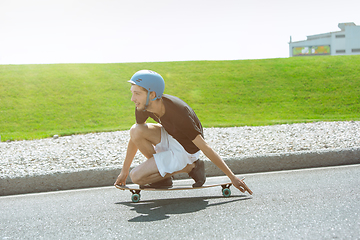 Image showing Skateboarder doing a trick at the city\'s street in sunny day