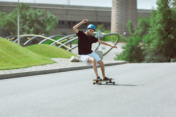 Image showing Skateboarder doing a trick at the city\'s street in sunny day