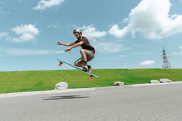 Image showing Skateboarder doing a trick at the city\'s street in sunny day