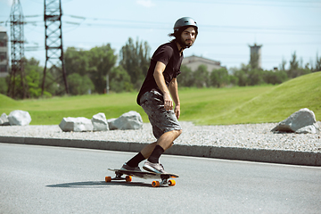 Image showing Skateboarder doing a trick at the city\'s street in sunny day