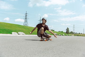 Image showing Skateboarder doing a trick at the city\'s street in sunny day