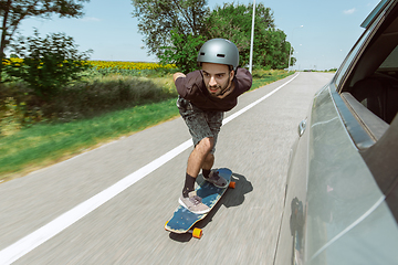 Image showing Skateboarder doing a trick at the city\'s street in sunny day