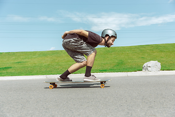 Image showing Skateboarder doing a trick at the city\'s street in sunny day