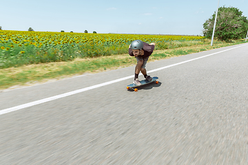 Image showing Skateboarder doing a trick at the city\'s street in sunny day