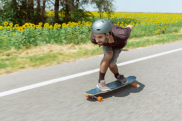 Image showing Skateboarder doing a trick at the city\'s street in sunny day