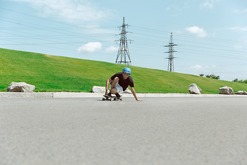 Image showing Skateboarder doing a trick at the city\'s street in sunny day