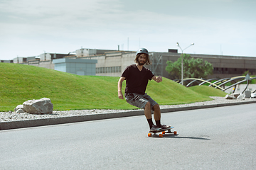 Image showing Skateboarder doing a trick at the city\'s street in sunny day