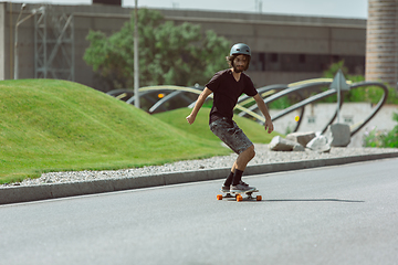 Image showing Skateboarder doing a trick at the city\'s street in sunny day