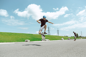 Image showing Skateboarders doing a trick at the city\'s street in sunny day