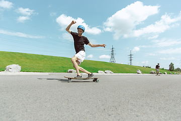 Image showing Skateboarders doing a trick at the city\'s street in sunny day