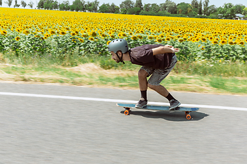 Image showing Skateboarder doing a trick at the city\'s street in sunny day