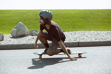 Image showing Skateboarder doing a trick at the city\'s street in sunny day