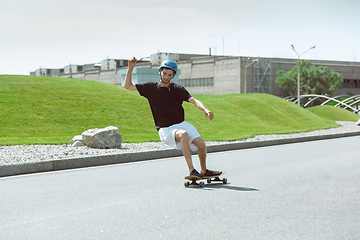 Image showing Skateboarder doing a trick at the city\'s street in sunny day