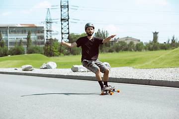 Image showing Skateboarder doing a trick at the city\'s street in sunny day