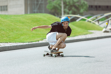 Image showing Skateboarder doing a trick at the city\'s street in sunny day