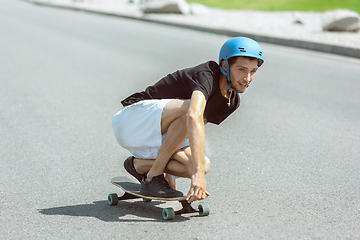 Image showing Skateboarder doing a trick at the city\'s street in sunny day