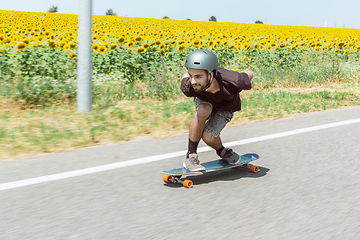 Image showing Skateboarder doing a trick at the city\'s street in sunny day