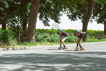 Image showing Skateboarders doing a trick at the city\'s street in sunny day