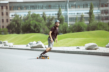 Image showing Skateboarder doing a trick at the city\'s street in sunny day