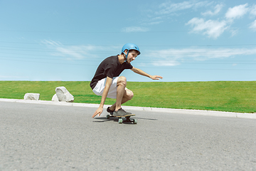 Image showing Skateboarder doing a trick at the city\'s street in sunny day