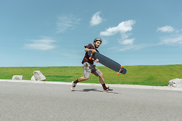 Image showing Skateboarder doing a trick at the city\'s street in sunny day