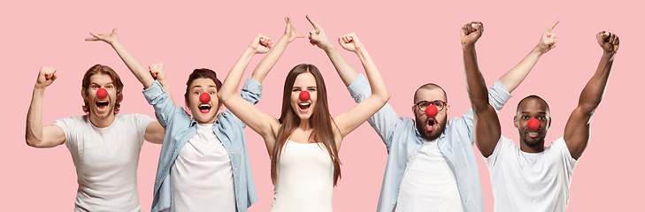 Image showing Portrait of young people celebrating red nose day on coral background