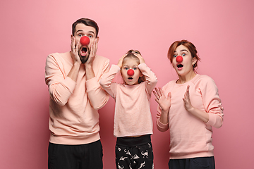 Image showing Portrait of young family celebrating red nose day on coral background