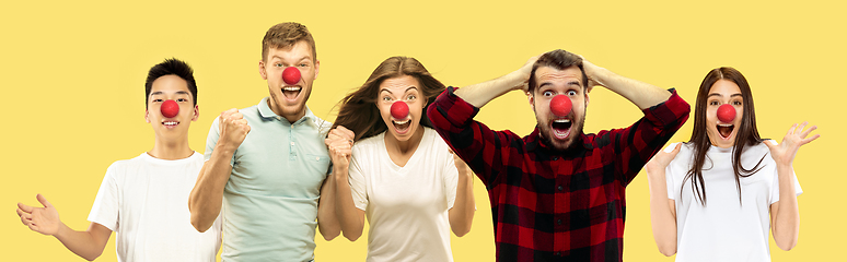 Image showing Portrait of beautiful people celebrating red nose day on yellow studio background