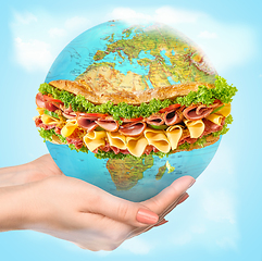 Image showing Save healthy food - female hands holding a globe as a sandwich