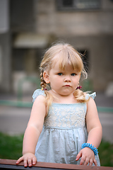 Image showing Little girl in an urban setting smiles at the camera.