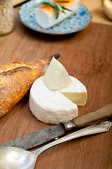 Image showing French cheese and fresh  baguette on a wood cutter