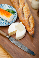 Image showing French cheese and fresh  baguette on a wood cutter