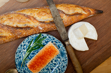 Image showing French cheese and fresh  baguette on a wood cutter