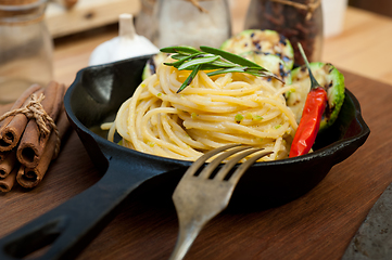 Image showing italian spaghetti pasta with zucchini sauce on iron skillet