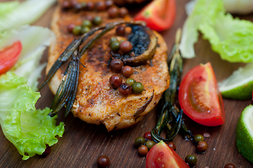 Image showing wood fired hoven cooked chicken breast on wood board 