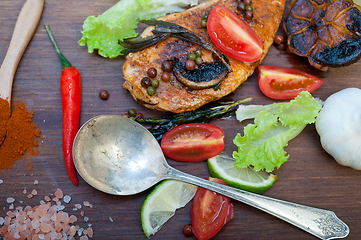 Image showing wood fired hoven cooked chicken breast on wood board 