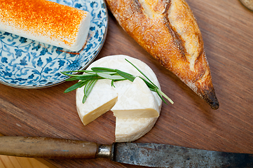 Image showing French cheese and fresh  baguette on a wood cutter