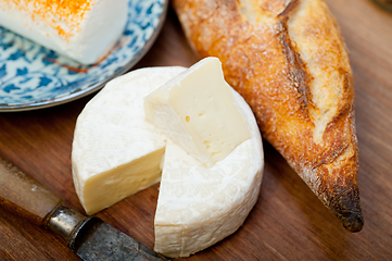 Image showing French cheese and fresh  baguette on a wood cutter