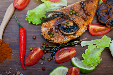 Image showing wood fired hoven cooked chicken breast on wood board 